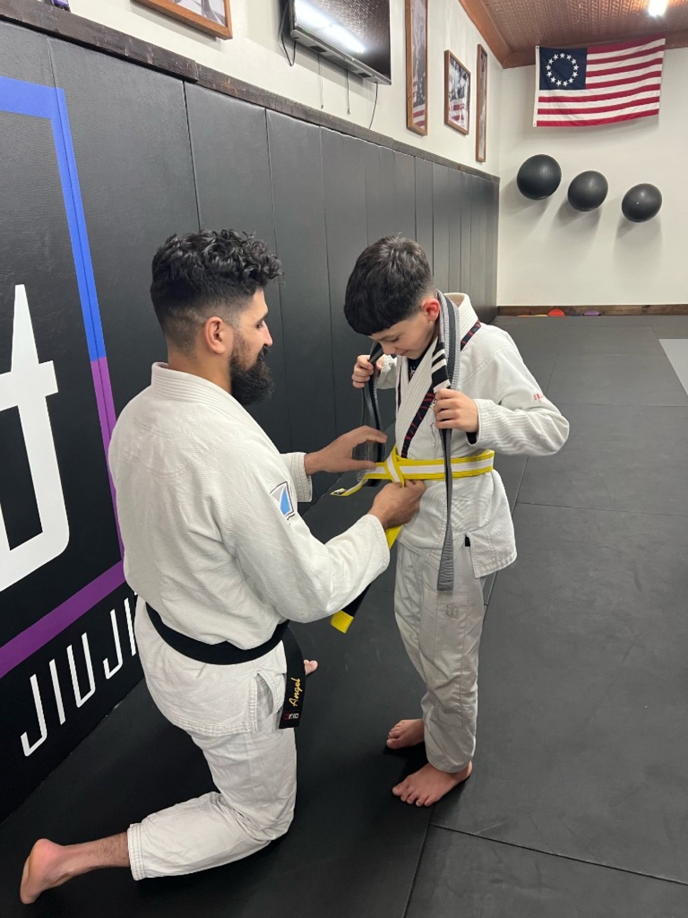 Tying a yellow belt on the mats at 144BJJ