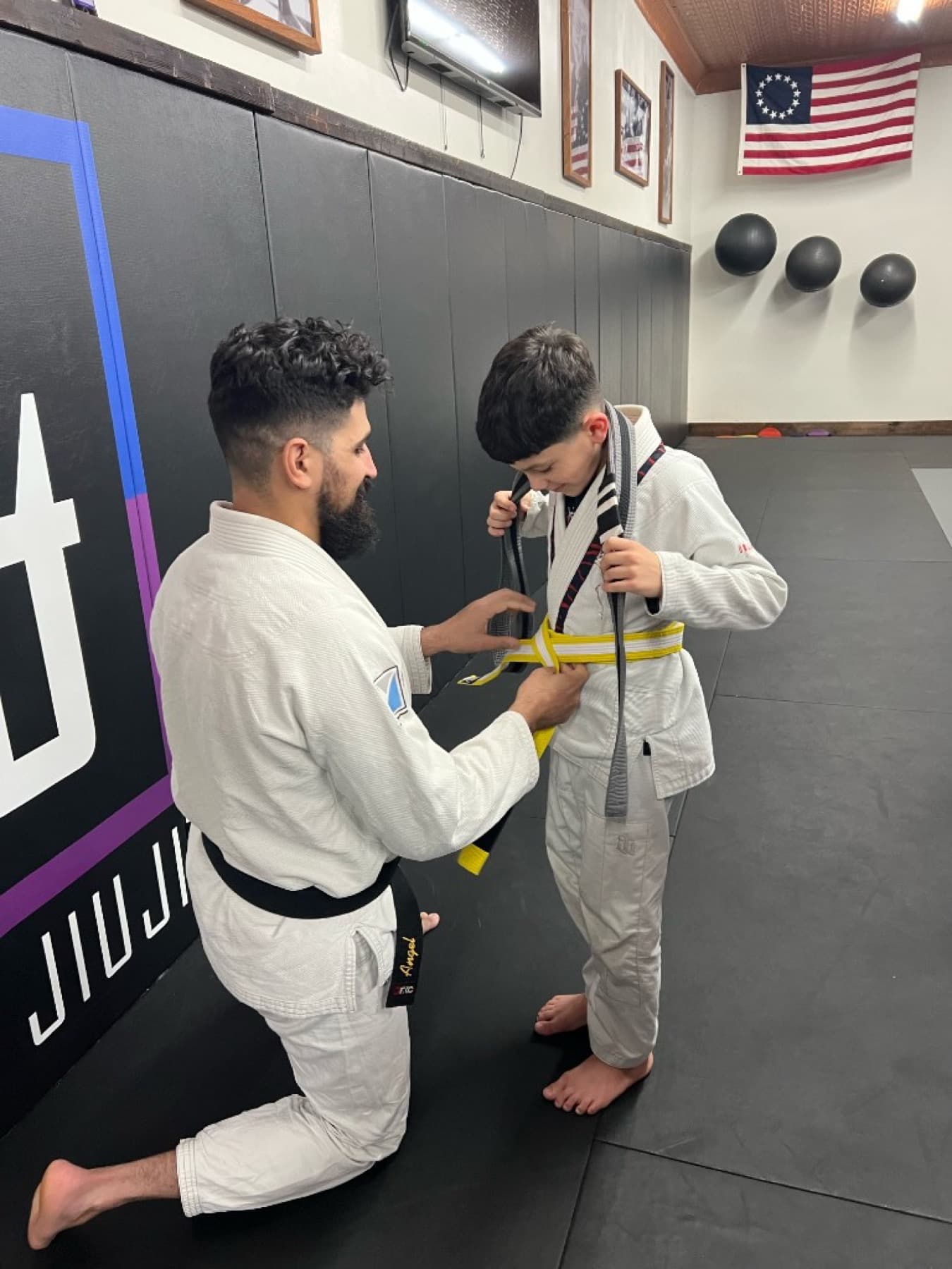 Tying a yellow belt on the mats at 144BJJ
